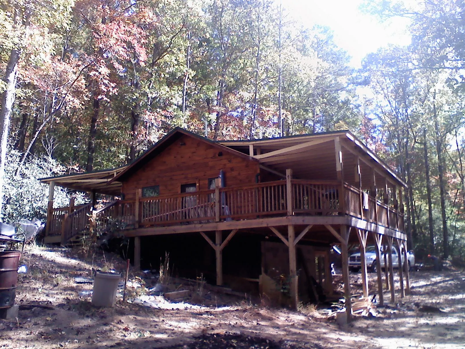 Log cabin with a wraparound porch and metal roof in the fall in Warrenville